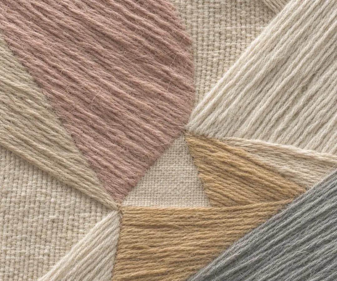 Embroidered wool triangles in blush, sand and ochre on natural linen